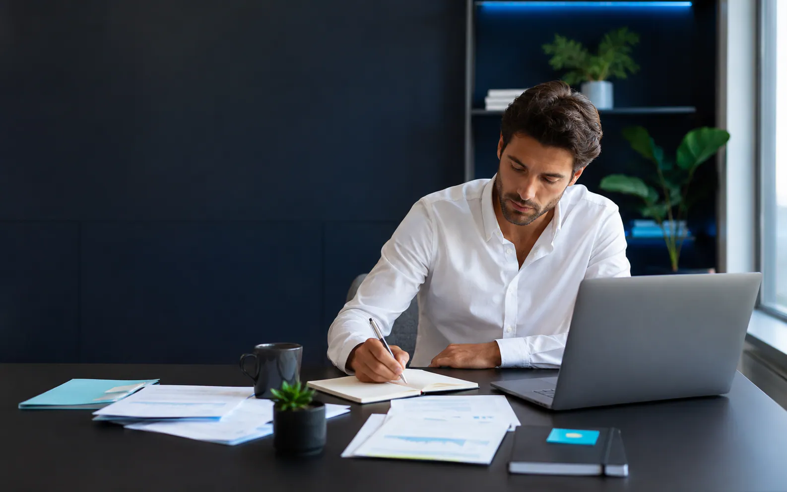 Entrepreneur structurant seul son activité avec ses notes et son ordinateur.